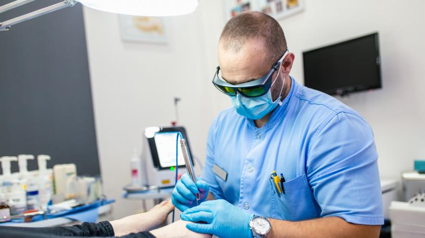 A podiatrist works on a patient's foot